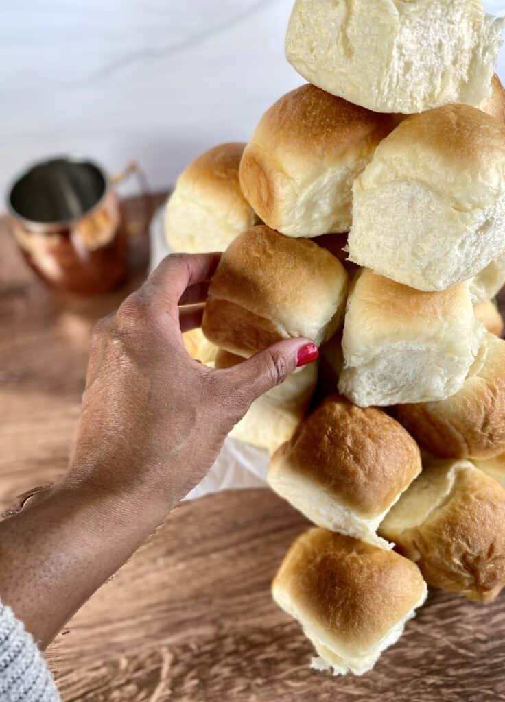 Stacked dinner rolls on a table.