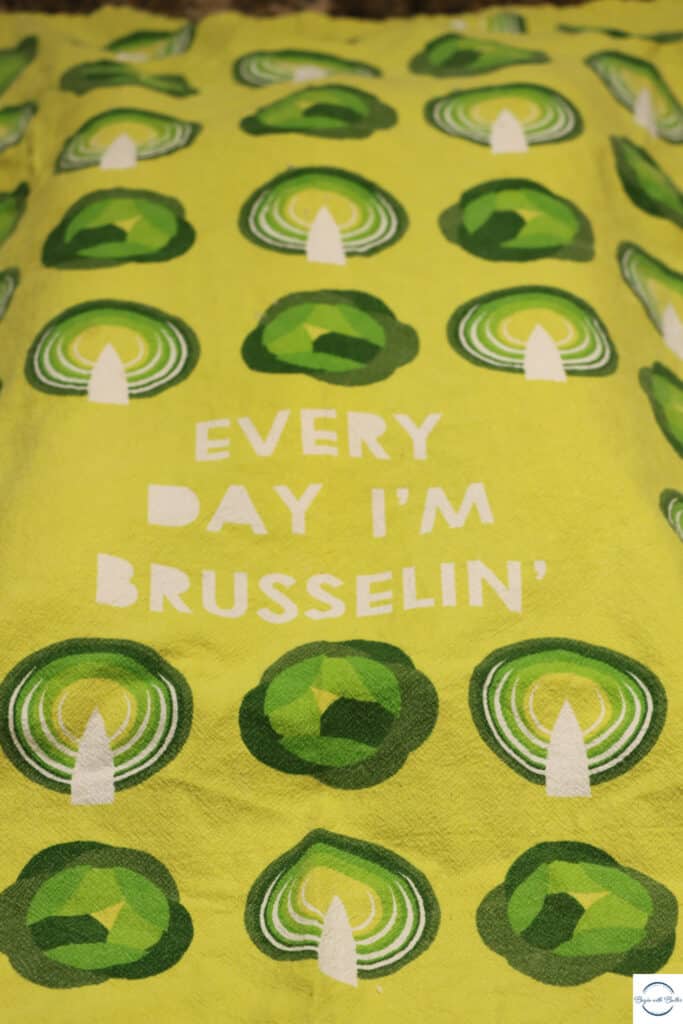 This is a picture of dough rising under a tea towel that says "Every Day I'm Brusselin"